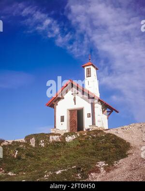 Italien. Das Bild zeigt die Bergsteigerkapelle auf der drei Zinnen Hütte in der Nähe der berühmten drei Türme, die auf Deutsch drei Zinnen heißen, aber auf Italienisch poetischer Weise als die wahre Zime di Laverado in der Region Sexten-Sexten-Sexten im Osten der italienischen Dolomiten bezeichnet werden. Während des Ersten Weltkriegs, bekannt als der Weiße Krieg, stellten die Gipfel eine natürliche Barriere zwischen den Italienern und den streikenden Österreichern dar, wobei die Front durch die Gipfel lief. Stockfoto