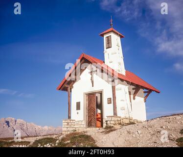 Italien. Das Bild zeigt die Bergsteigerkapelle auf der drei Zinnen Hütte in der Nähe der berühmten drei Türme, die auf Deutsch drei Zinnen heißen, aber auf Italienisch poetischer Weise als die wahre Zime di Laverado in der Region Sexten-Sexten-Sexten im Osten der italienischen Dolomiten bezeichnet werden. Während des Ersten Weltkriegs, bekannt als der Weiße Krieg, stellten die Gipfel eine natürliche Barriere zwischen den Italienern und den streikenden Österreichern dar, wobei die Front durch die Gipfel lief. Stockfoto