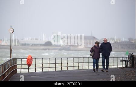 In Southsea, Hampshire, wandern die Menschen entlang der Küste, und Wind und Regen prognostizierten, dass Großbritannien am ersten Freitag verwüstet werden wird, an dem Menschen in großen Gruppen außerhalb Englands zusammentreffen durften. Bilddatum: Freitag, 21. Mai 2021. Stockfoto