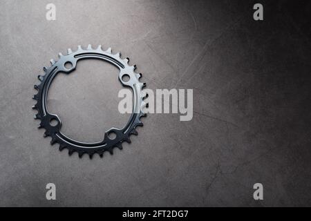 Sternenzähnchen-Muster mit Fahrradketten-Mechanismen auf schwarzem Hintergrund. Dark Key, Draufsicht Black Star Pleuelsystem für schmale breite Fahrräder. ----- Stockfoto