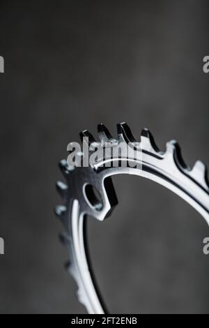Sternenzähnchen-Muster mit Fahrradketten-Mechanismen auf schwarzem Hintergrund. Dark Key, Draufsicht Black Star Pleuelsystem für schmale breite Fahrräder. Stockfoto