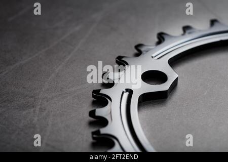 Schwarzer Stern des schmalen breiten Fahrrad-Pleuelsystems. Ein Zahnmuster eines fahrenden Fahrradstars auf schwarzem Hintergrund. Dunkle Taste, Draufsicht Stockfoto