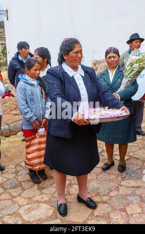 Die örtliche Quechua-Frau verteilt Hochzeitsgeschenke bei einer Hochzeit in Chinchero, einem rustikalen Andendorf im Heiligen Tal, Urubamba, Region Cusco, Peru Stockfoto