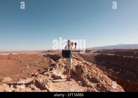 Ein Tourist fotografiert die atemberaubende Wüstenlandschaft in der Nähe von San Pedro De Atacama, Chile. Stockfoto