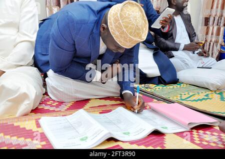 KAMPALA, UGANDA - 14. Apr 2021: Der muslimische Mann, der den Heiratsvertrag unterzeichnet, um seine Ehe legal zu machen, und Sie können sie auf Ihre Art und Weise versuchen Stockfoto