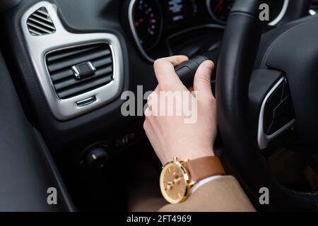 Beschnittene Ansicht des Mannes mit Armbanduhr mit Blinker während Auto fahren Stockfoto