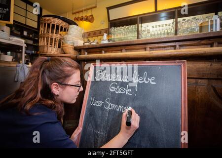 Potsdam, Deutschland. Mai 2021. Romy Wismer, eine Kellnerin, schreibt auf einer Tafel in einem französischen Restaurant in Potsdam. Quelle: Christoph Soeder/dpa/Alamy Live News Stockfoto