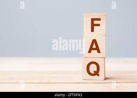 Holzwürfelblöcke mit FAQ-Text (häufig gestellte Fragen) auf Tischhintergrund. Finanz-, Marketing- und Geschäftskonzepte Stockfoto