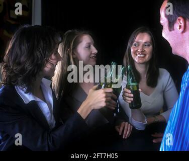 2005 HISTORISCHE KAUKASISCHE BÜROANGESTELLTE STOSSEN AN DER BAR UND TRINKEN BIER ALLE MODELLE ÜBER 25 JAHRE ALT Stockfoto