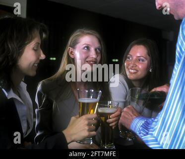 2005 HISTORISCHE KAUKASISCHE BÜROANGESTELLTE STOSSEN AN DER BAR UND TRINKEN BIER ALLE MODELLE ÜBER 25 JAHRE ALT Stockfoto