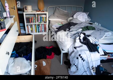 Teenage Boy GCSE Teenager Teenager 15 16 Teenager unordentliche Schlafzimmer ungebaute Bett Bücher Computer offene Schubladen blaue Wände in Großbritannien KATHY DEWITT Stockfoto