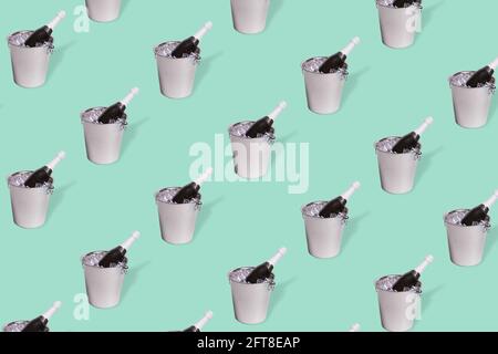 Kreatives Muster mit einer Flasche Champagner in einem Eiskübel auf pastellgrünem Hintergrund. Minimales Konzept von Feier, Jubiläum und Liebe Stockfoto