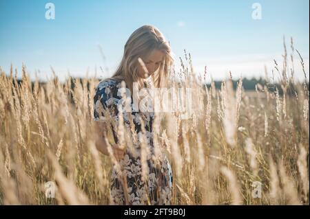 Schönheit Romantische Mädchen Im Freien. Schöne Teenage Model Mädchen in Casual Kleid auf dem Feld in Sun Light gekleidet. Leuchtende Sonne, Sonnenschein Stockfoto