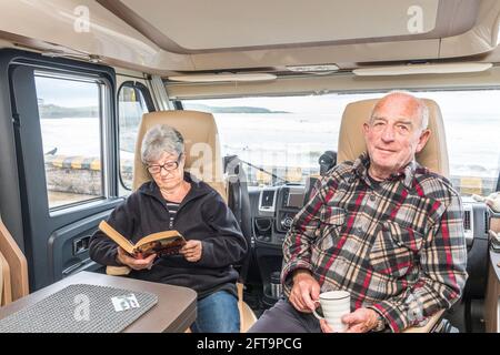 Garrettstown, Cork, Irland. Mai 2021. Nach ein paar Tagen Sturm an der Küste entspannen sich die beiden Rentner Margaret und John O'Brien in ihrem Wohnmobil am Meer in Garrettstown, Co. Cork, Irland.- Credit; David Creedon / Alamy Live News Stockfoto