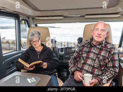 Garrettstown, Cork, Irland. Mai 2021. Nach ein paar Tagen Sturm an der Küste entspannen sich die beiden Rentner Margaret und John O'Brien in ihrem Wohnmobil am Meer in Garrettstown, Co. Cork, Irland.- Credit; David Creedon / Alamy Live News Stockfoto