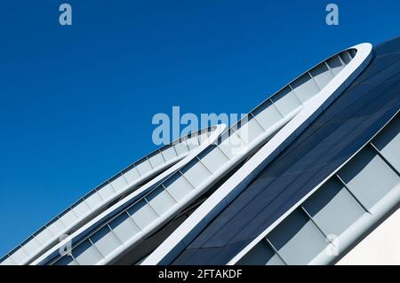 Gateshead, Großbritannien - 6. April 2019: Nahaufnahme der geschwungenen Stahldachlinie des Sage-Gebäudes in Gateshead, vor blauem Himmel. Stockfoto