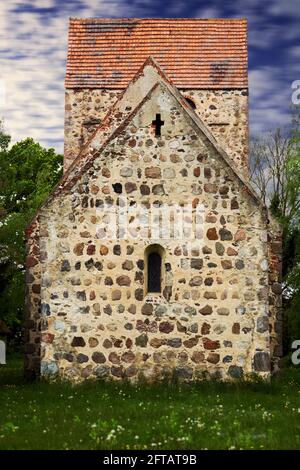 Blick auf die alte verlassene Dorfkirche aus Feldsteinen Auf grünem Rasen Stockfoto