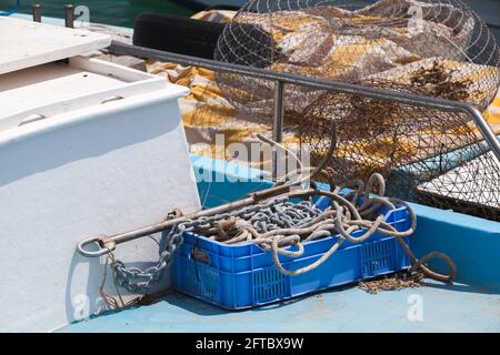 Kleine Ausrüstung für Fischerboote. Seile, Käfige und Anker lagen auf einem blauen Deck Stockfoto