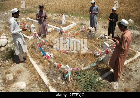 (210521) -- JALALABAD, 21. Mai 2021 (Xinhua) -- Verwandte beten über die Gräber der Opfer, die von US-Soldaten im Shinwar-Bezirk der Provinz Nangarhar, Afghanistan, 6. Mai 2021 getötet wurden. ZUM Feature: Das sogenannte „freundliche Feuer“ der US-Truppen verfolgt die Afghanen seit Jahrzehnten (Foto: Saifurahman Safi/Xinhua) Stockfoto