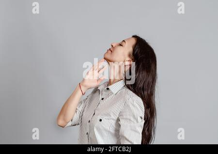 Eine Frau mittleren Alters hält ihre Hand nahe an ihrem Kinn. Stockfoto
