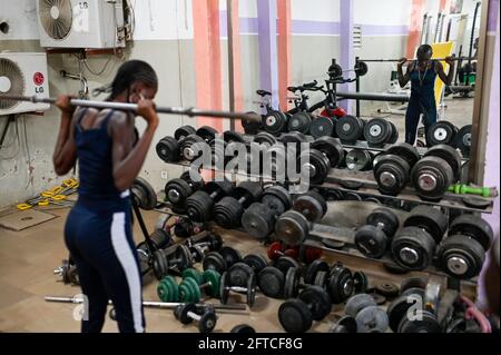 SENEGAL, Thies, Gym, Fitness and Body Building Studio, junge Frau beim Training mit Gewichtheben / junge Frau im Fitness Studio, Training mit Gewichten heben Stockfoto