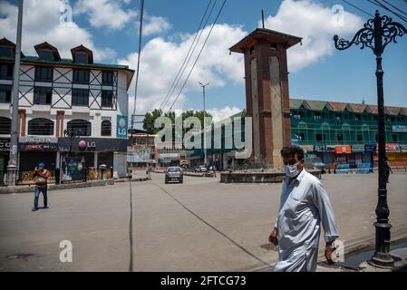 Srinagar, Indien. Mai 2021. Ein Mann mit Gesichtsmaske als Vorsichtsmaßnahme gegen die Ausbreitung von covid-19 geht während der Beschränkungen in Lal chowk auf einer verlassenen Straße.die Behörden haben am Freitag die Ausgangssperre von Covid-19 im Bezirk Srinagar am Vorabend des Todestages von Mirwaiz Molvi Mohammad Farooq und Abdul Ghani Lone verschärft, Die am 21. Mai in Kaschmir markiert wird. Kredit: SOPA Images Limited/Alamy Live Nachrichten Stockfoto