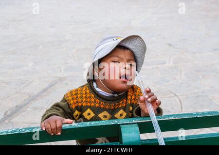 Ein lokaler Junge mit Quechua Down-Syndrom in Chinchero, einem kleinen rustikalen Dorf der Anden im Heiligen Tal, Provinz Urubamba, Region Cusco, Peru Stockfoto