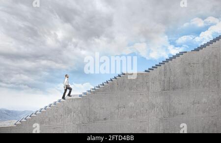 Geschäftsmann steigt eine lange Leiter zum Himmel. Konzept der Entschlossenheit und Aspiration. Stockfoto