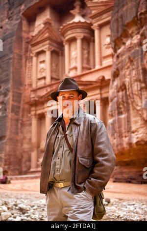 US-Tourist, der als Harrison Ford vor dem Finanzministerium (Al-Khazneh) gekleidet ist, ein Ort von „Indiana Jones und der letzte Kreuzzug“. Stockfoto