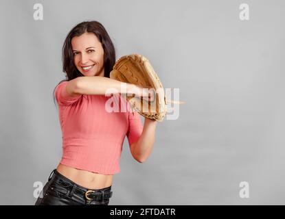 Frau, die einen Baseballhandschuh in der Hand hält und Baseballspiele spielt. Aktiver Sport Stockfoto