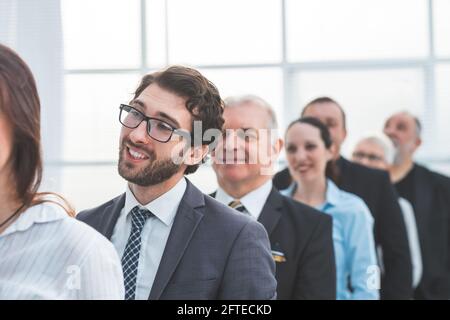 Nahaufnahme. Eine Gruppe von verschiedenen Geschäftsleuten wartet, die der Reihe nach stehen. Stockfoto