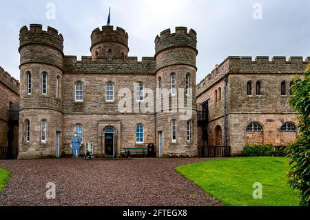 Das viereckige Gefängnishaus im Jedburgh Old Prison mit Türmen an jeder Ecke mit zementierten Brüstungen und einem rechteckigen Gefängnisblock an einer Seite Stockfoto