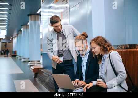 Junge Geschäftsleute diskutieren Arbeitsfragen auf der U-Bahn-Plattform . Stockfoto