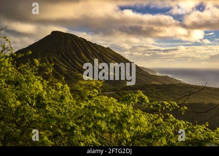 Ruhiger, ruhiger Sonnenaufgang über der Hanauma Bay, einem der beliebtesten Reiseziele für Schnorcheln und Schwimmen, und dem Koko Head Crater, Oahu, Honolulu, Hawaii, USA Stockfoto