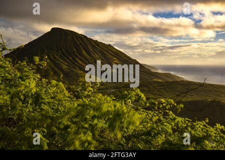 Ruhiger, ruhiger Sonnenaufgang über der Hanauma Bay, einem der beliebtesten Reiseziele für Schnorcheln und Schwimmen, und dem Koko Head Crater, Oahu, Honolulu, Hawaii, USA Stockfoto