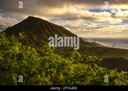 Ruhiger, ruhiger Sonnenaufgang über der Hanauma Bay, einem der beliebtesten Reiseziele für Schnorcheln und Schwimmen, und dem Koko Head Crater, Oahu, Honolulu, Hawaii, USA Stockfoto