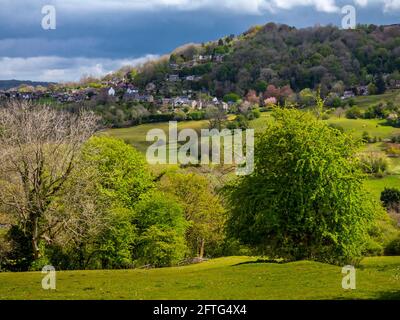 Blick über Felder in Richtung Starkholmes Dorf von Matlock Bath im Derbyshire Dales Peak District England mit Bäumen in Frühlingsfarben. Stockfoto