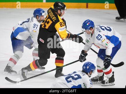 Riga, Lettland. Mai 2021. Eishockey: Weltmeisterschaft, Vorrunde, Gruppe B, Deutschland - Italien. Der deutsche Leonhard Pföderl (M) versucht sich gegen den italienischen Phil Pietroniro (l) und Stefano Marchetti durchzusetzen. Quelle: Roman Koksarov/dpa/Alamy Live News Stockfoto