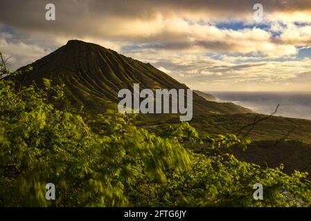 Ruhiger, ruhiger Sonnenaufgang über der Hanauma Bay, einem der beliebtesten Reiseziele für Schnorcheln und Schwimmen, und dem Koko Head Crater, Oahu, Honolulu, Hawaii, USA Stockfoto