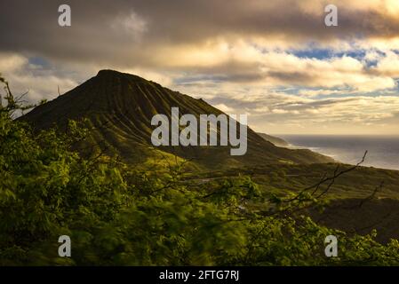 Ruhiger, ruhiger Sonnenaufgang über der Hanauma Bay, einem der beliebtesten Reiseziele für Schnorcheln und Schwimmen, und dem Koko Head Crater, Oahu, Honolulu, Hawaii, USA Stockfoto