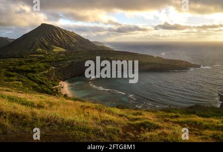 Ruhiger, ruhiger Sonnenaufgang über der Hanauma Bay, einem der beliebtesten Reiseziele für Schnorcheln und Schwimmen, und dem Koko Head Crater, Oahu, Honolulu, Hawaii, USA Stockfoto