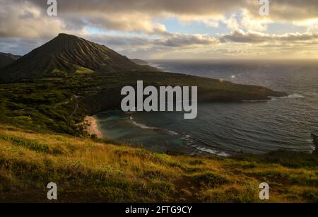 Ruhiger, ruhiger Sonnenaufgang über der Hanauma Bay, einem der beliebtesten Reiseziele für Schnorcheln und Schwimmen, und dem Koko Head Crater, Oahu, Honolulu, Hawaii, USA Stockfoto