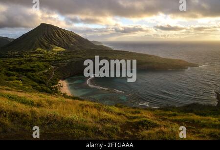 Ruhiger, ruhiger Sonnenaufgang über der Hanauma Bay, einem der beliebtesten Reiseziele für Schnorcheln und Schwimmen, und dem Koko Head Crater, Oahu, Honolulu, Hawaii, USA Stockfoto