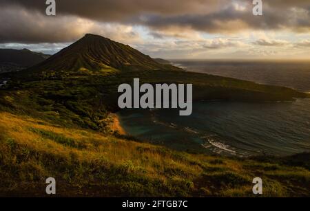 Ruhiger, ruhiger Sonnenaufgang über der Hanauma Bay, einem der beliebtesten Reiseziele für Schnorcheln und Schwimmen, und dem Koko Head Crater, Oahu, Honolulu, Hawaii, USA Stockfoto