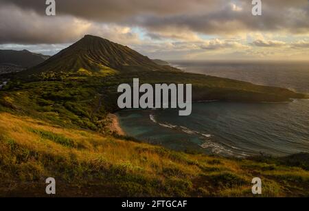 Ruhiger, ruhiger Sonnenaufgang über der Hanauma Bay, einem der beliebtesten Reiseziele für Schnorcheln und Schwimmen, und dem Koko Head Crater, Oahu, Honolulu, Hawaii, USA Stockfoto