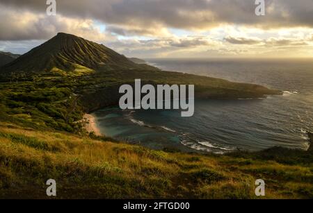 Ruhiger, ruhiger Sonnenaufgang über der Hanauma Bay, einem der beliebtesten Reiseziele für Schnorcheln und Schwimmen, und dem Koko Head Crater, Oahu, Honolulu, Hawaii, USA Stockfoto