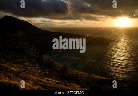 Ruhiger, ruhiger Sonnenaufgang über der Hanauma Bay, einem der beliebtesten Reiseziele für Schnorcheln und Schwimmen, und dem Koko Head Crater, Oahu, Honolulu, Hawaii, USA Stockfoto