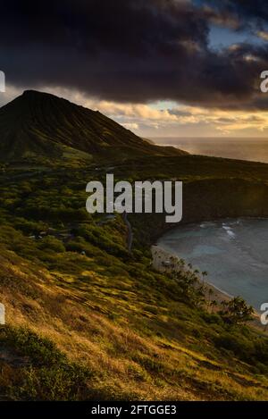 Ruhiger, ruhiger Sonnenaufgang über der Hanauma Bay, einem der beliebtesten Reiseziele für Schnorcheln und Schwimmen, und dem Koko Head Crater, Oahu, Honolulu, Hawaii, USA Stockfoto