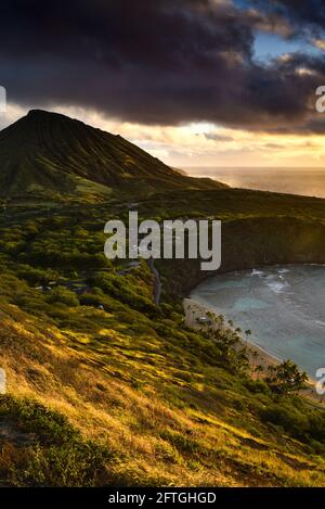 Ruhiger, ruhiger Sonnenaufgang über der Hanauma Bay, einem der beliebtesten Reiseziele für Schnorcheln und Schwimmen, und dem Koko Head Crater, Oahu, Honolulu, Hawaii, USA Stockfoto