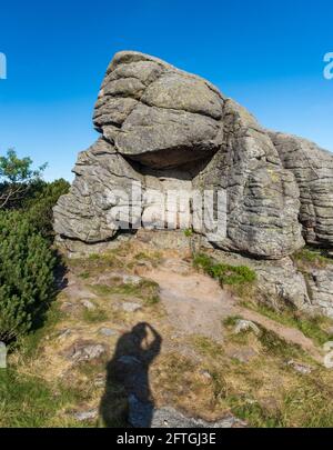 Felsformation mit dem Schatten des Fotografen - Tvaroznik im Riesengebirge Auf tschechisch - polnisch Grenzen während des Sommerabends mit klar Himmel Stockfoto